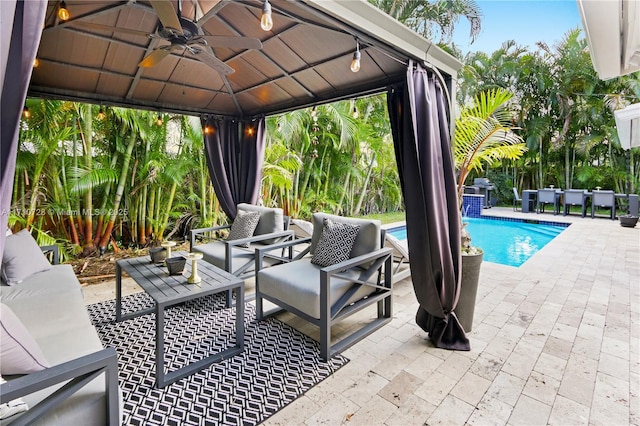 exterior space featuring outdoor lounge area, an outdoor pool, and a gazebo