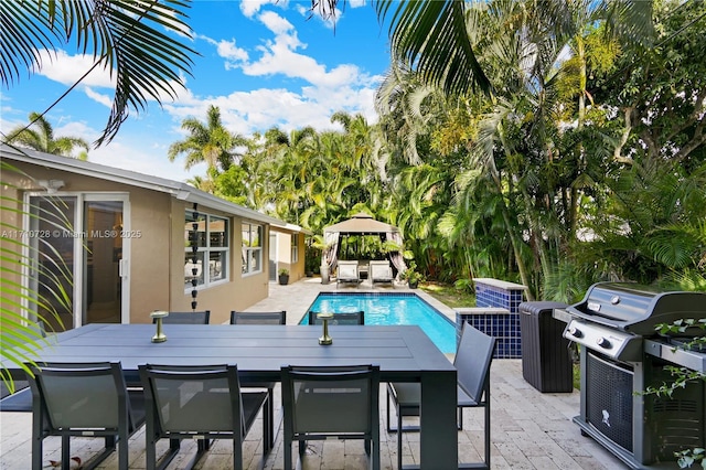 pool featuring a patio area, outdoor dining area, and a gazebo