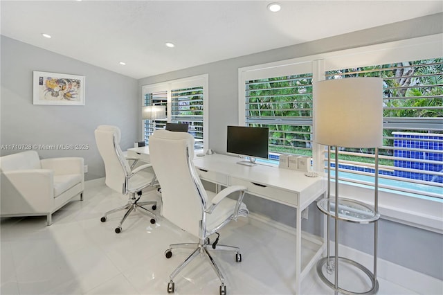 tiled office with vaulted ceiling and recessed lighting