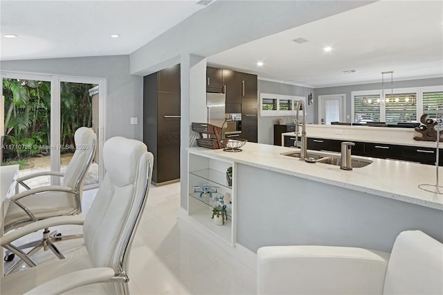 kitchen featuring dark brown cabinets, light stone counters, modern cabinets, and recessed lighting