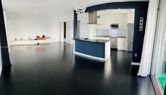 kitchen with white cabinets, stainless steel appliances, extractor fan, and a notable chandelier