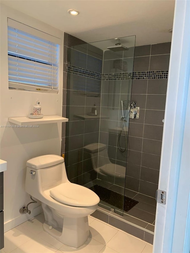 bathroom with tile patterned floors, toilet, and a tile shower