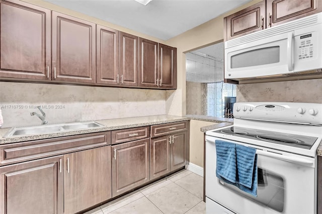 kitchen with sink, light tile patterned floors, and white appliances