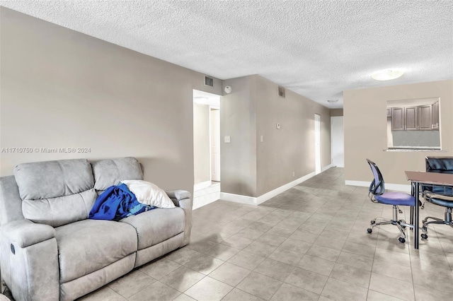 office space with a textured ceiling and light tile patterned flooring