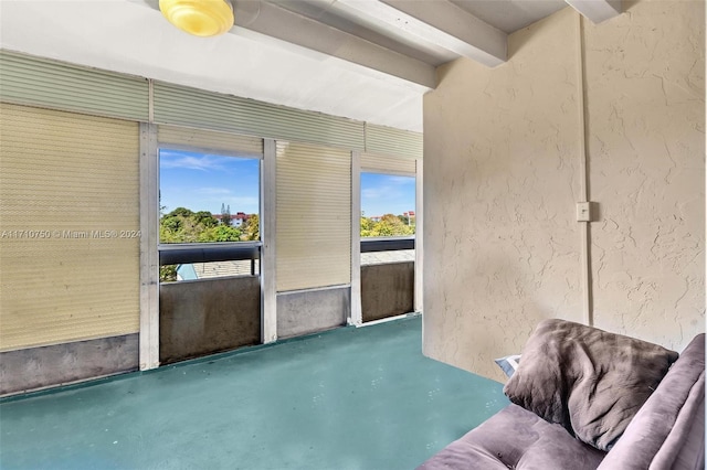 unfurnished sunroom featuring beamed ceiling