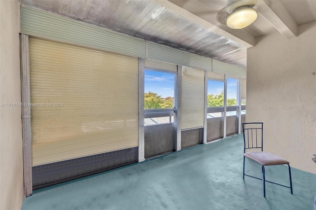 unfurnished sunroom with beam ceiling