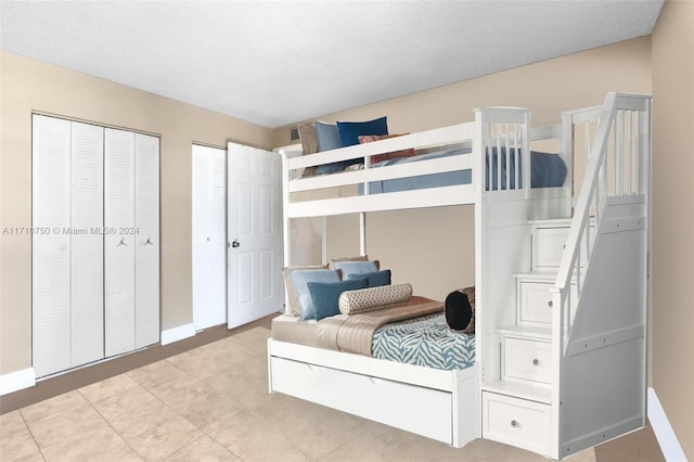 bedroom with a textured ceiling and two closets