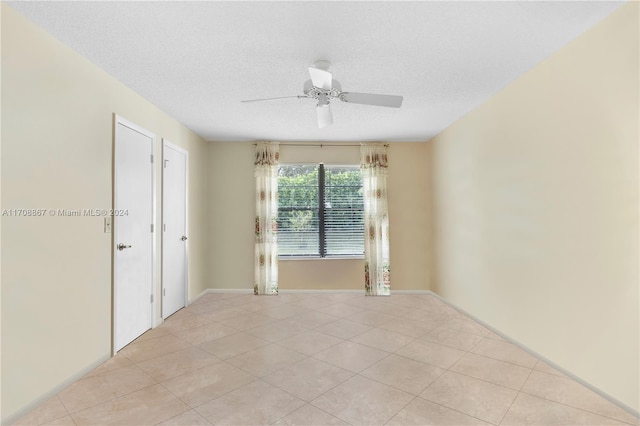 empty room featuring ceiling fan and a textured ceiling