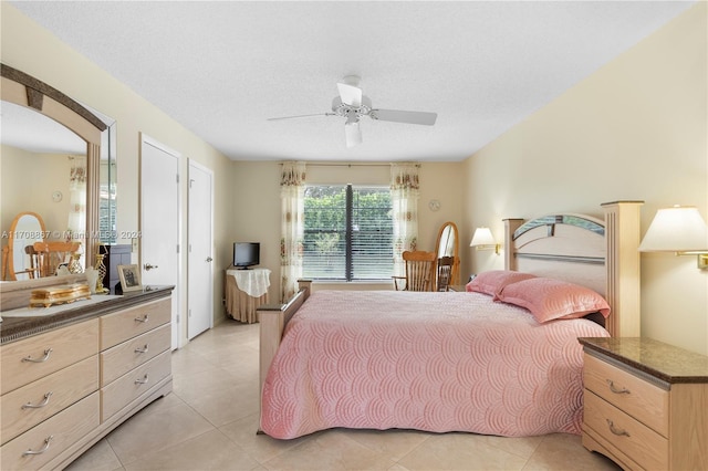 bedroom featuring light tile patterned floors, a textured ceiling, and ceiling fan