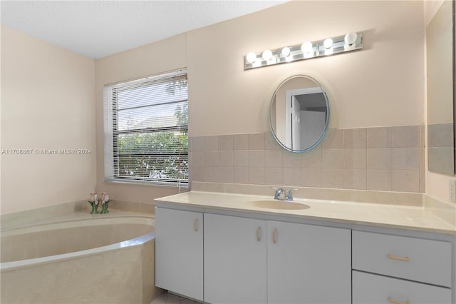 bathroom with a bath, a textured ceiling, and vanity