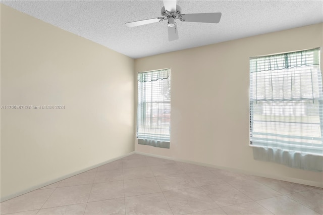 tiled spare room featuring ceiling fan and a textured ceiling