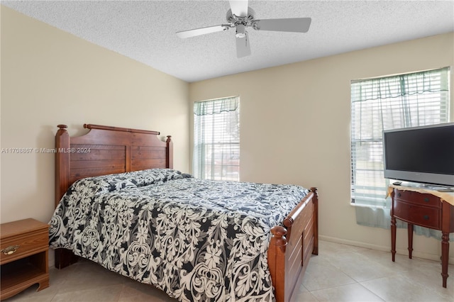 bedroom with light tile patterned floors, a textured ceiling, and ceiling fan