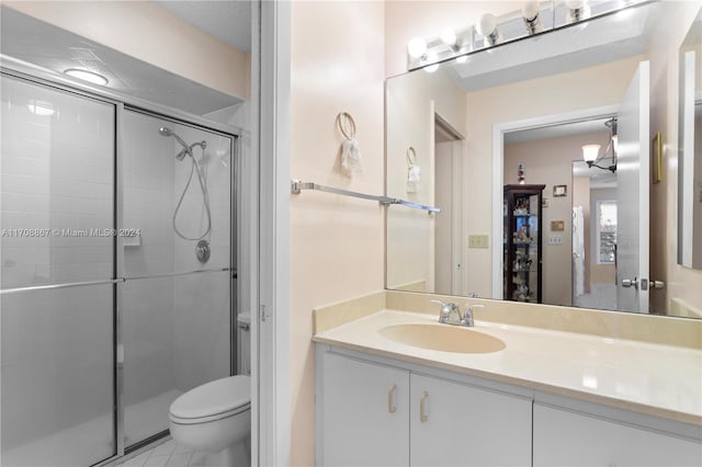 bathroom with tile patterned flooring, vanity, toilet, and an enclosed shower