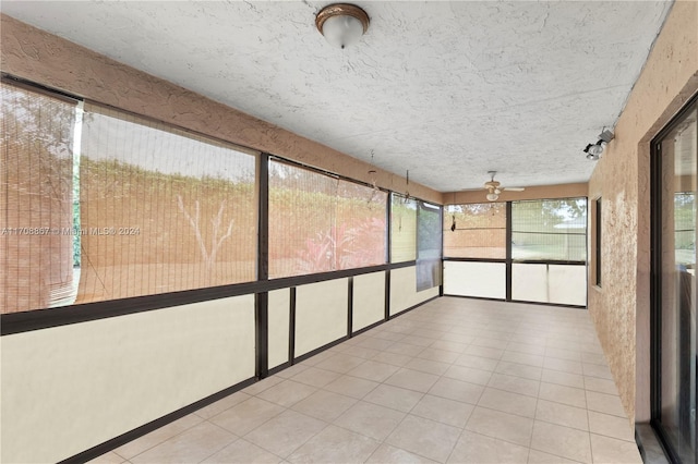 unfurnished sunroom featuring ceiling fan