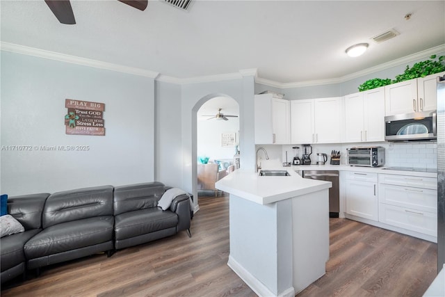 kitchen featuring white cabinets, kitchen peninsula, sink, and appliances with stainless steel finishes