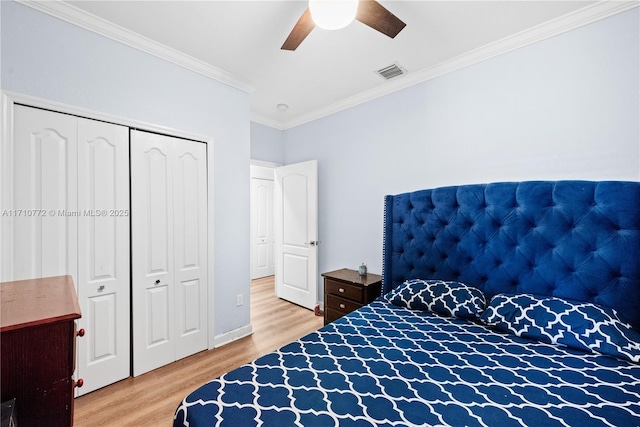 bedroom with hardwood / wood-style floors, ceiling fan, crown molding, and a closet