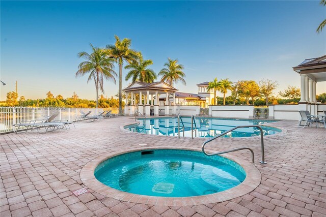 view of swimming pool featuring a patio and a hot tub