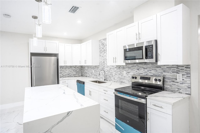 kitchen featuring white cabinetry, hanging light fixtures, and appliances with stainless steel finishes