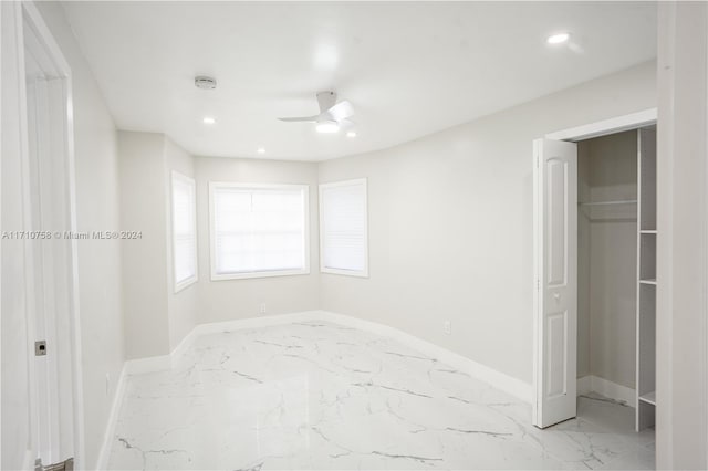 unfurnished bedroom featuring ceiling fan and a closet