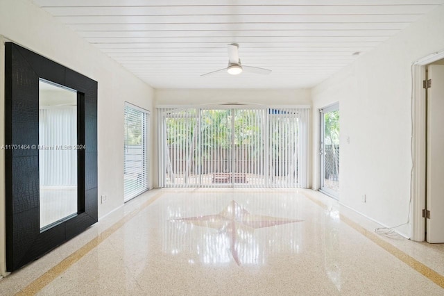 unfurnished sunroom featuring ceiling fan