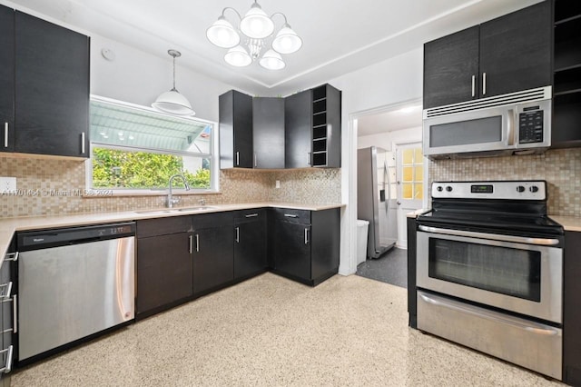 kitchen featuring decorative backsplash, stainless steel appliances, sink, decorative light fixtures, and a notable chandelier