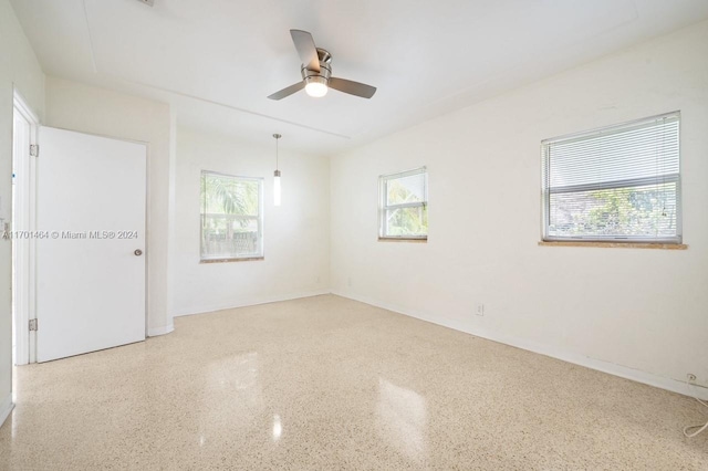 unfurnished room featuring ceiling fan and a wealth of natural light