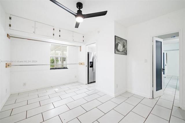 empty room featuring ceiling fan and light tile patterned flooring