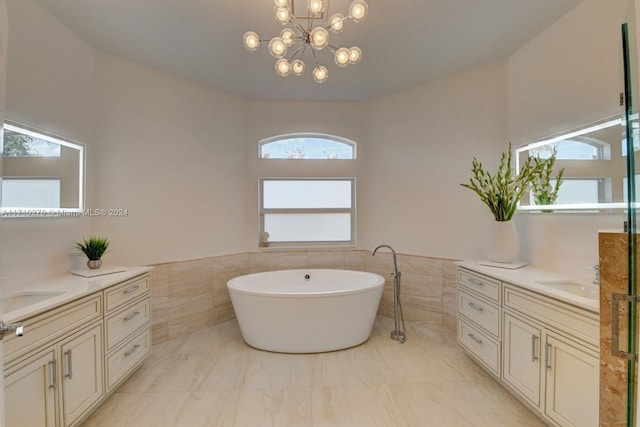 bathroom with a bathing tub, vanity, tile walls, and a notable chandelier