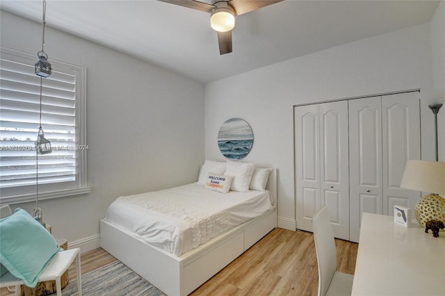 bedroom with ceiling fan, light hardwood / wood-style flooring, and a closet