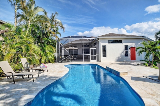 view of swimming pool featuring a lanai and a patio