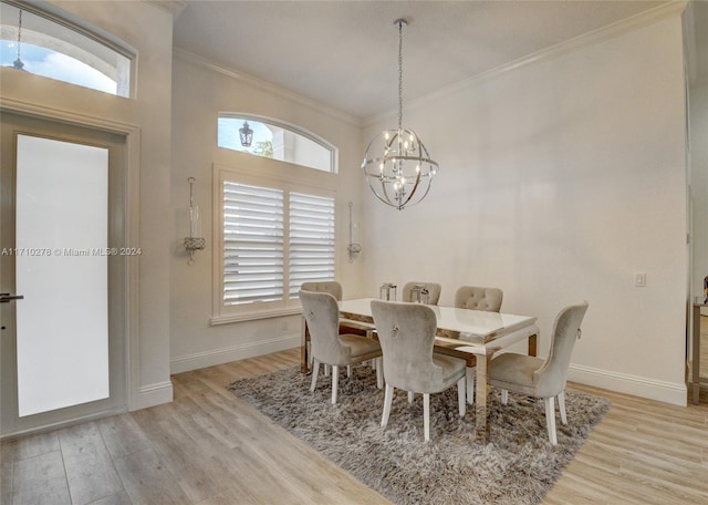 dining space with a notable chandelier, light wood-type flooring, and crown molding