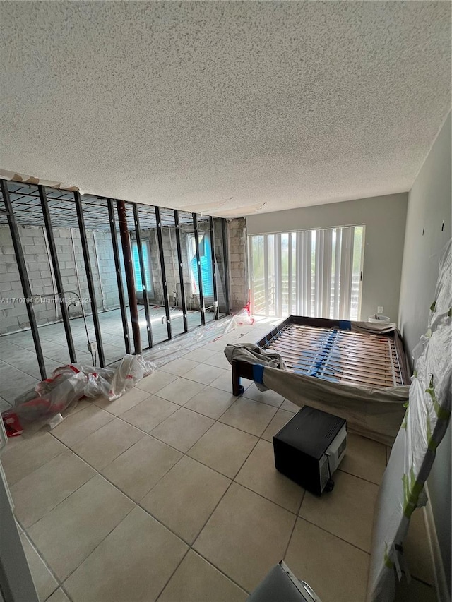 game room featuring a textured ceiling and light tile patterned flooring