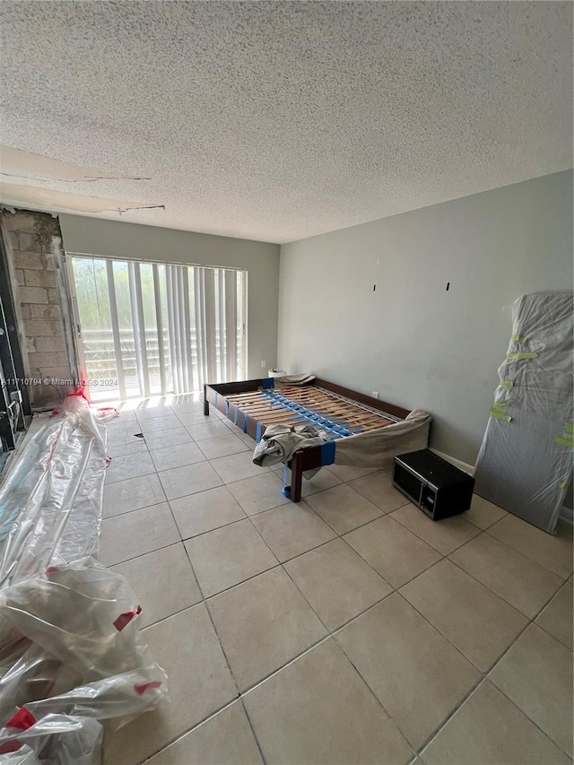 recreation room featuring light tile patterned floors and a textured ceiling