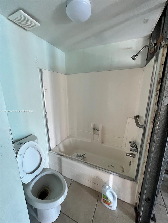 bathroom featuring tile patterned flooring, toilet, and shower / washtub combination