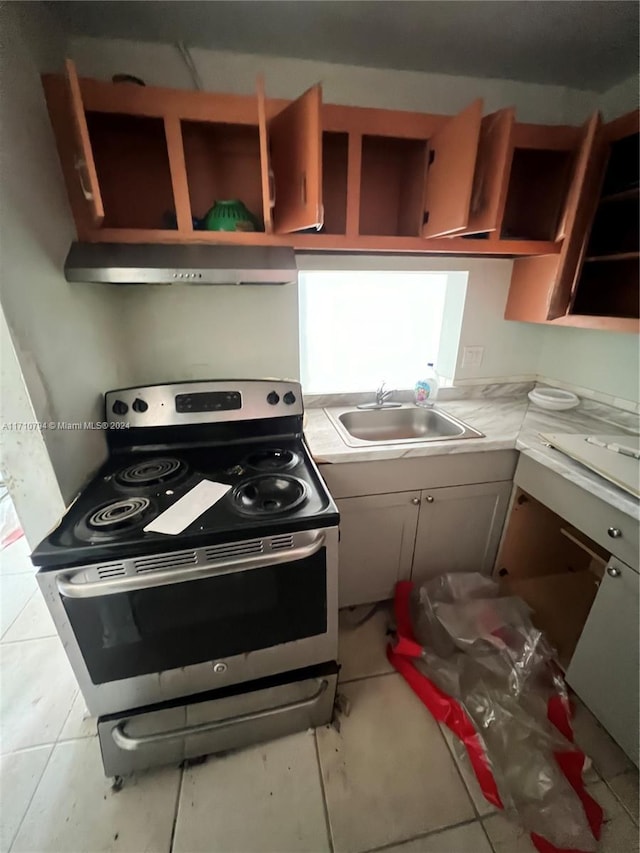 kitchen with electric stove, sink, and light tile patterned floors