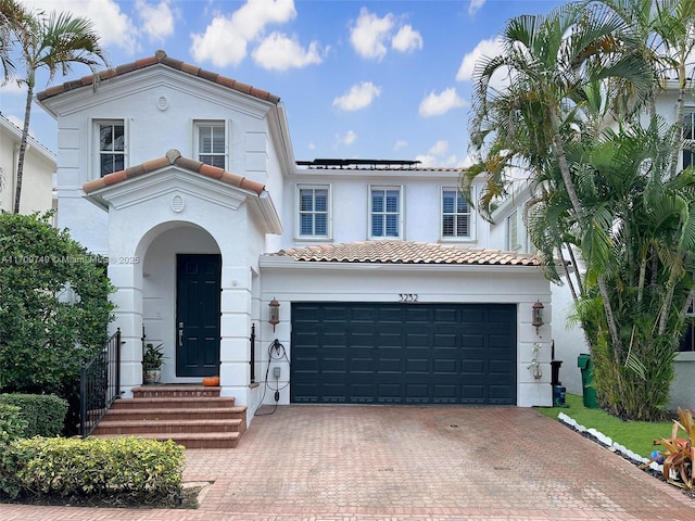 mediterranean / spanish-style house with a garage and solar panels