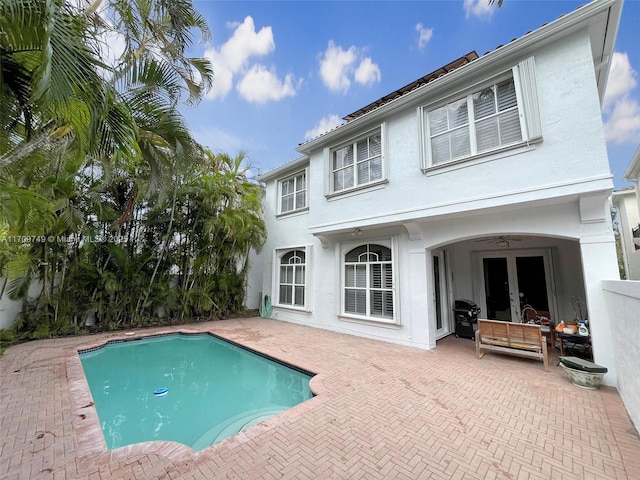 view of swimming pool with ceiling fan, a patio area, area for grilling, and french doors