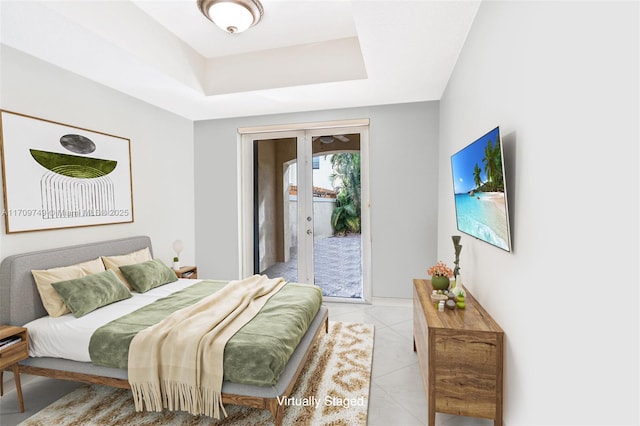 tiled bedroom with a tray ceiling, access to outside, and french doors