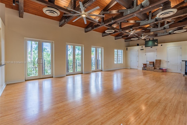 unfurnished living room with ceiling fan, french doors, plenty of natural light, wood ceiling, and high vaulted ceiling