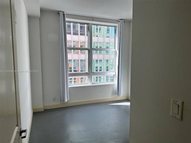 unfurnished room with plenty of natural light and concrete floors