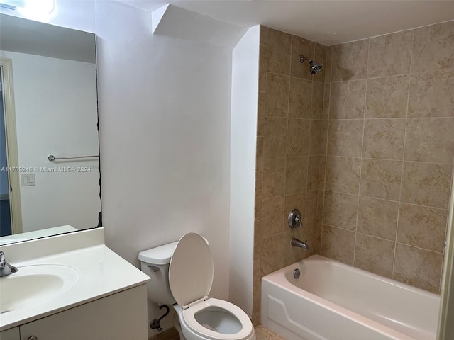 full bathroom featuring vanity, tiled shower / bath combo, and toilet