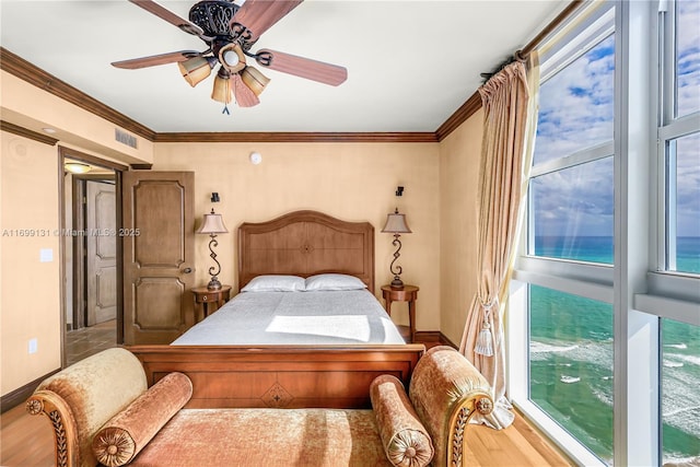 bedroom featuring multiple windows, ceiling fan, crown molding, and hardwood / wood-style flooring