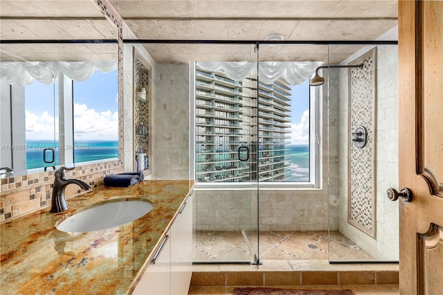 bathroom with vanity, a water view, and a shower with shower door