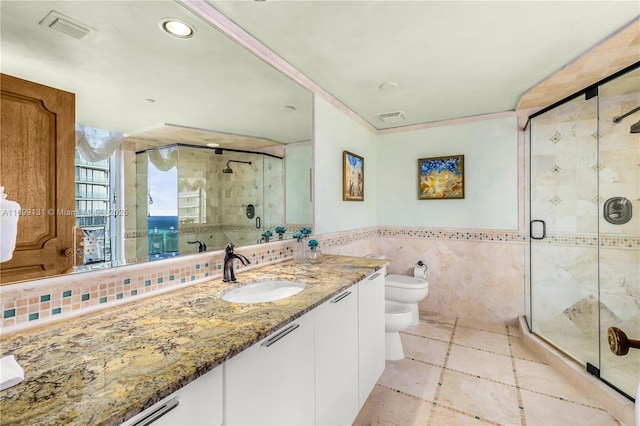 bathroom with vanity, a bidet, tile walls, toilet, and a shower with shower door