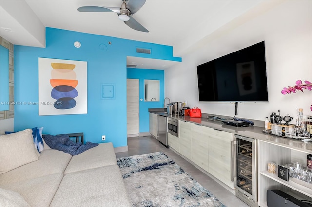 living room with wine cooler, ceiling fan, concrete flooring, and indoor bar