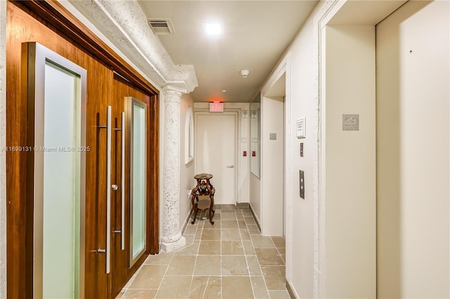 hallway featuring elevator and ornate columns