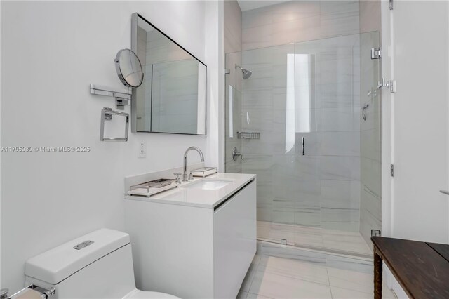 bathroom featuring tile patterned flooring, vanity, toilet, and a shower with door