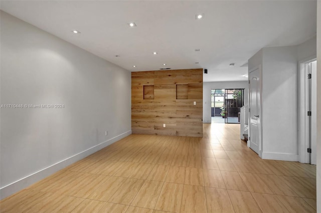 unfurnished room with wooden walls