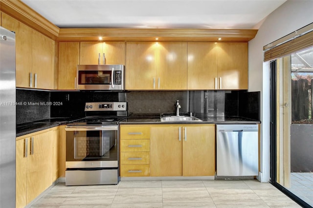 kitchen featuring backsplash, sink, appliances with stainless steel finishes, and dark stone counters