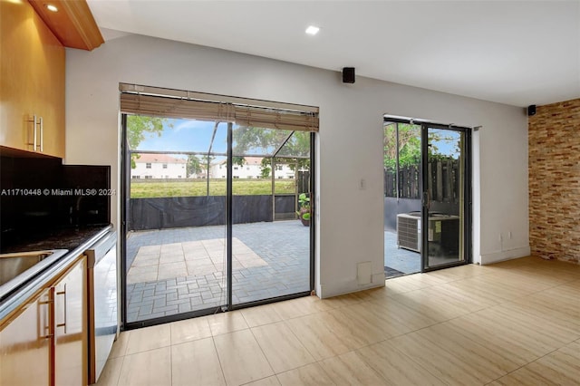 doorway to outside with a wealth of natural light and light tile patterned flooring